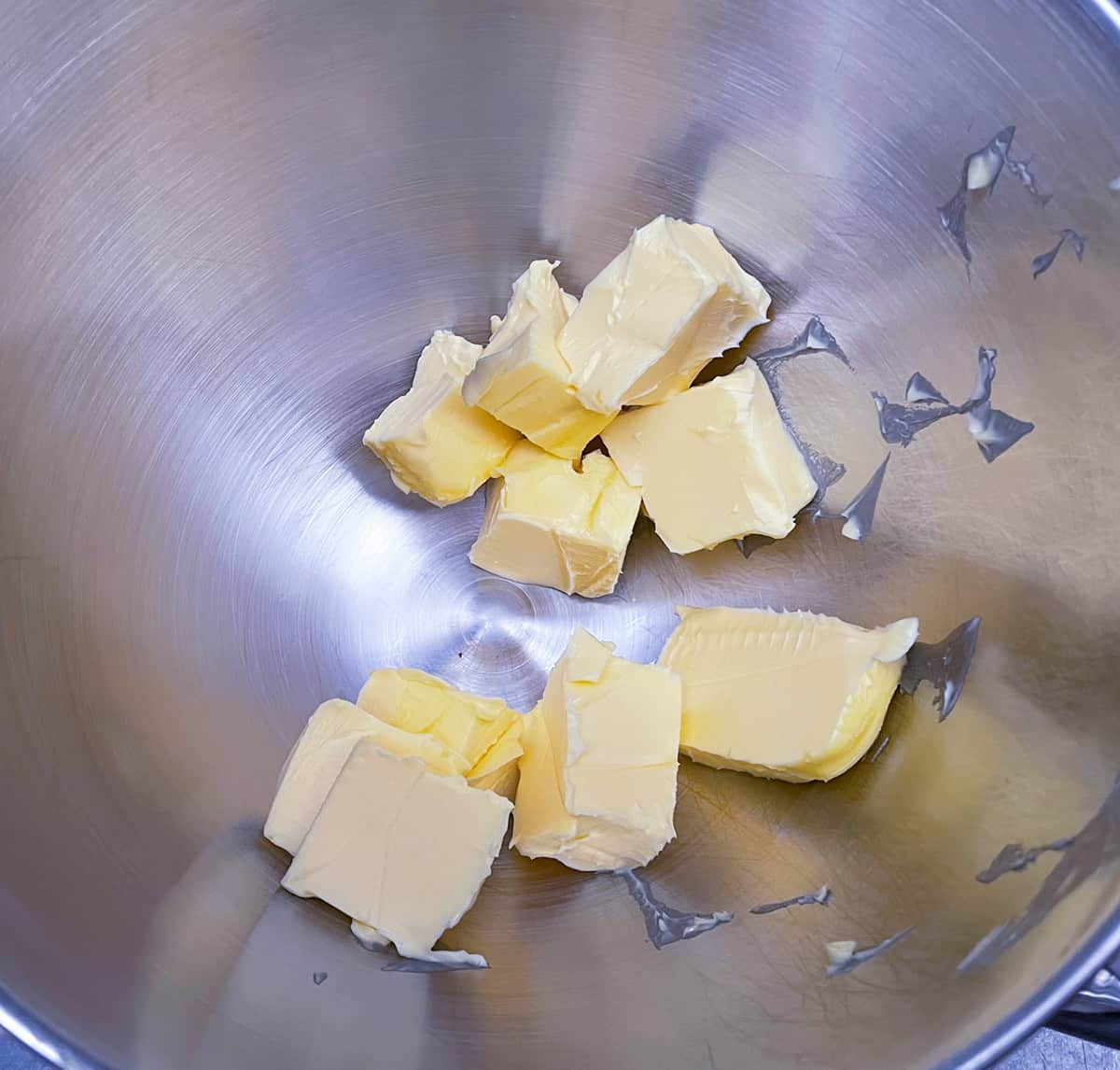 Butter cut into pieces and added to a mixer bowl.