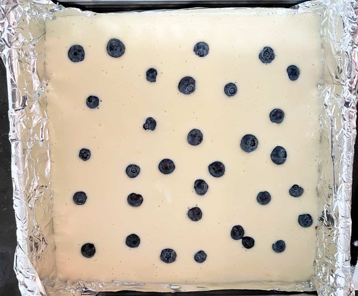 A few whole blueberries on the top of the cheesecake before going into the oven.