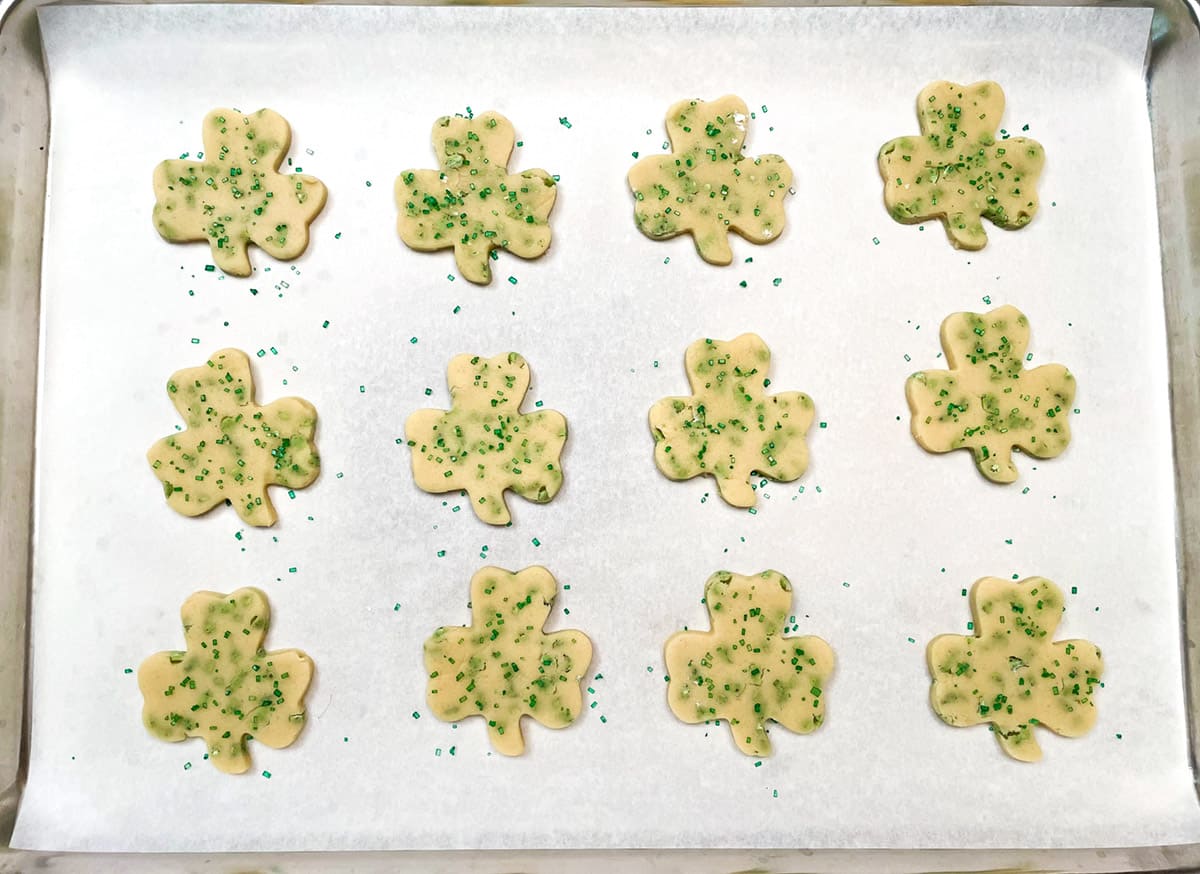 Shamrock cookies with green sparkle sugar on pan ready for the oven.