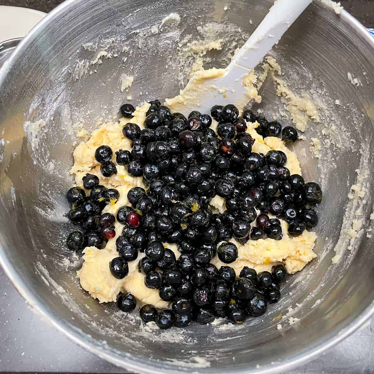 Adding the infused blueberries to the cookie batter.
