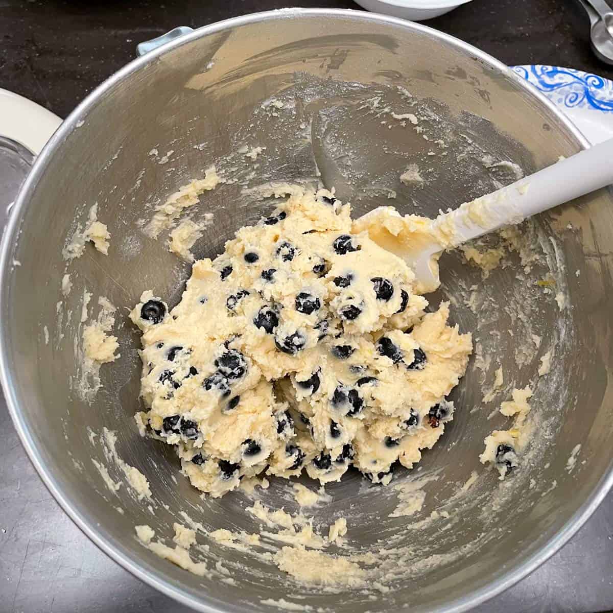 Blueberries being folded into cookie batter.