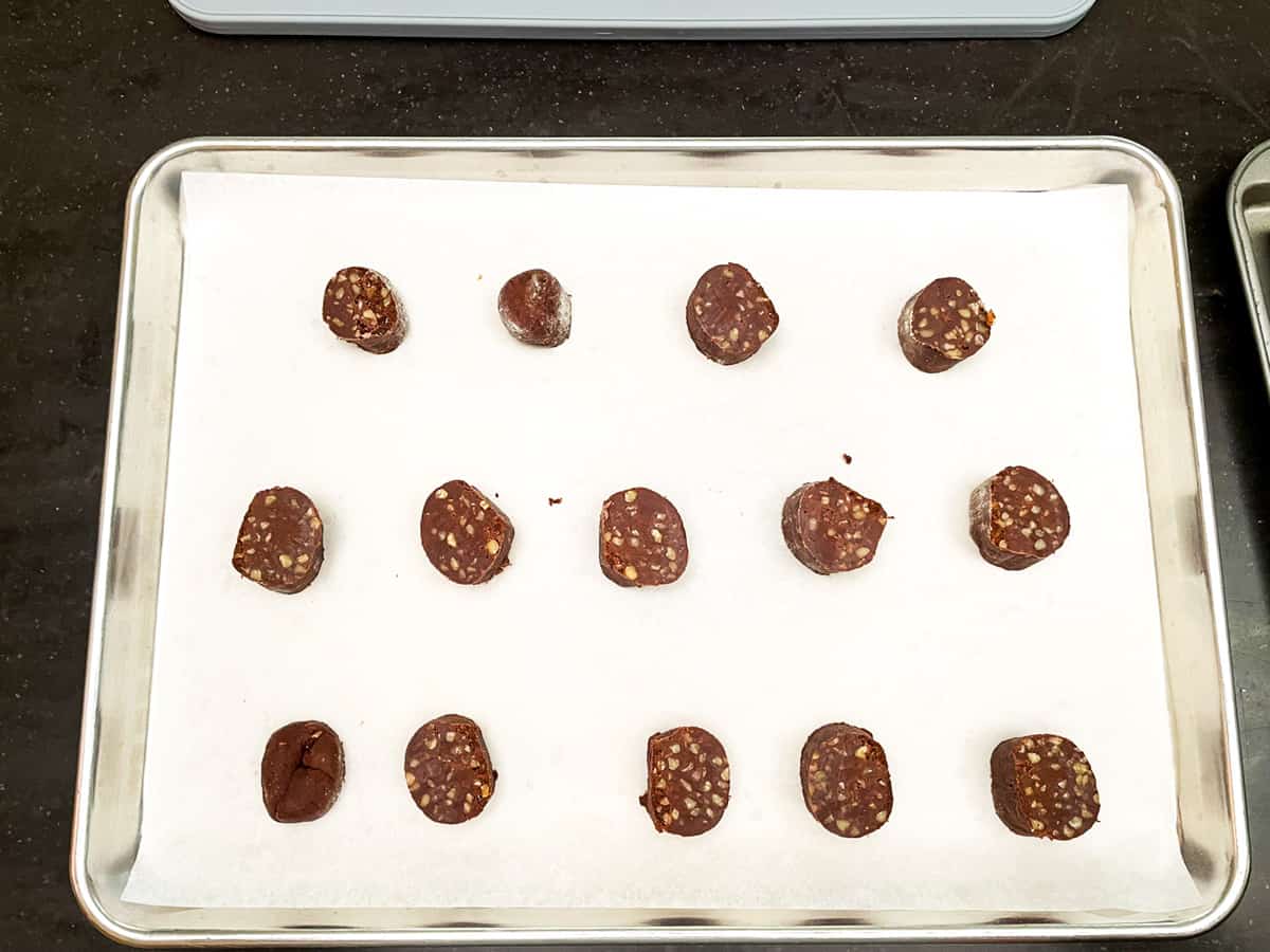 Cookie log sliced and placed on parchment lined cookie sheet pan.