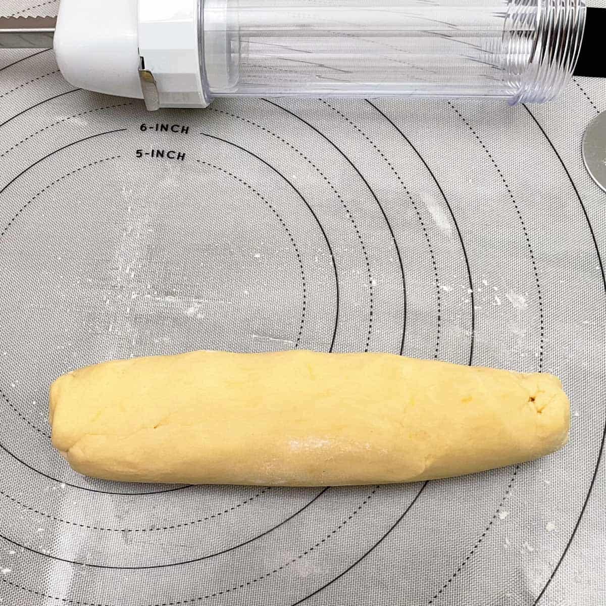 Roll the cookie dough on a lightly floured pastry mat so you can add to the cylinder of the spritz gun.