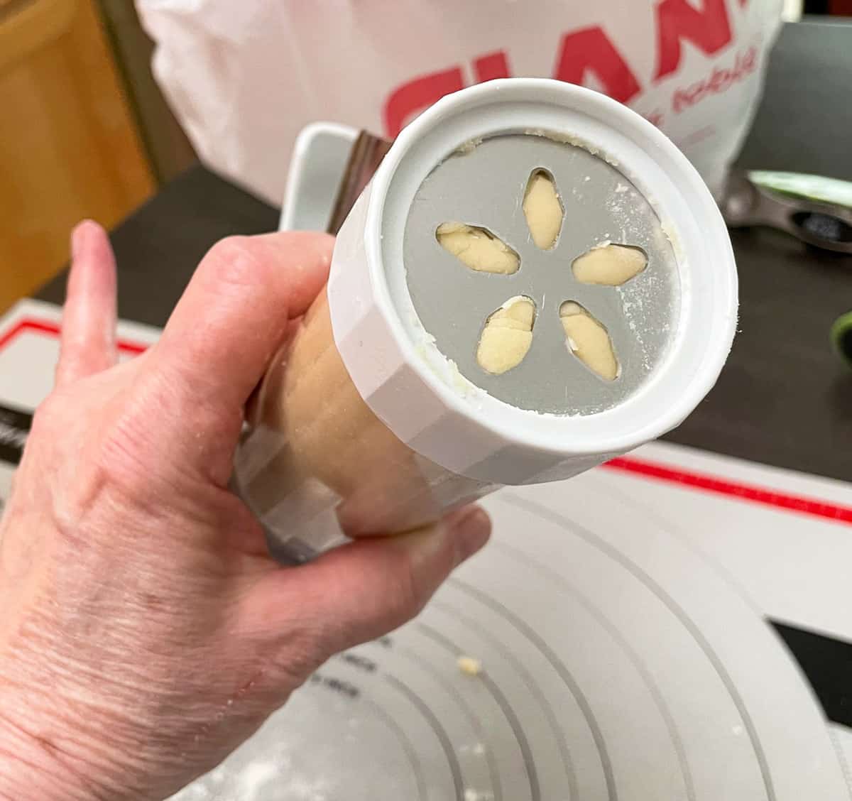 How the cookie dough should look after the cylinder has been filled and the cap screwed on a cookie press.