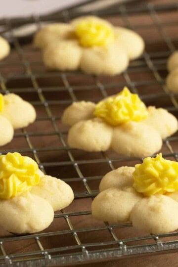 Flower spritz cookies for feature image sitting on a wire rack.