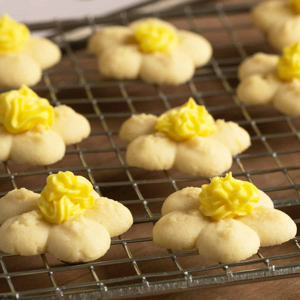 Flower spritz cookies for feature image sitting on a wire rack.