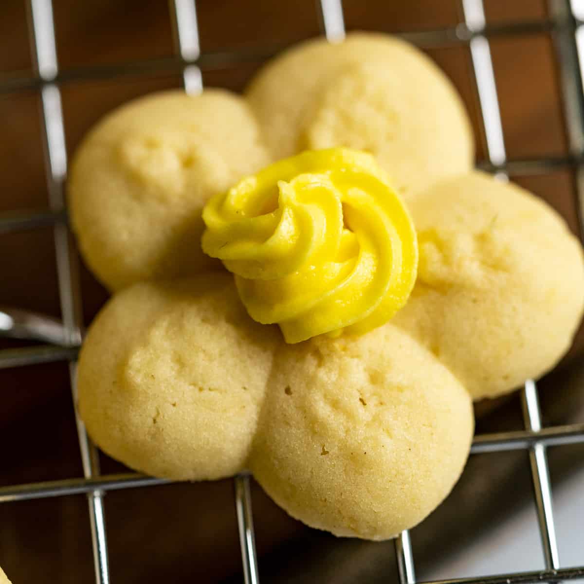 Single flower spritz cookie with center yellow icing.
