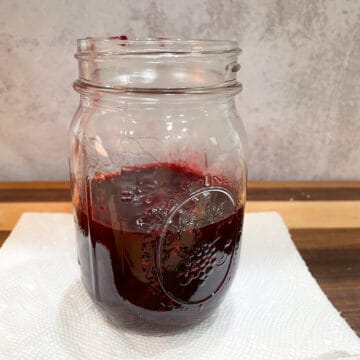 Finished blackberry and lemon puree cooling in a glass jar.