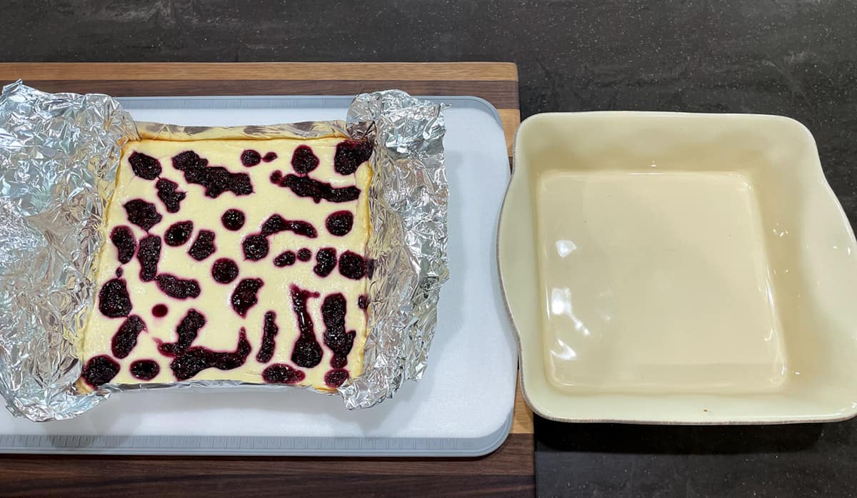 Using the overlapped tinfoil to lift cheesecake from baking dish.