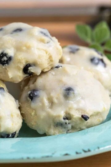 Blue plate with a stack of blueberry lemon cookies on it.