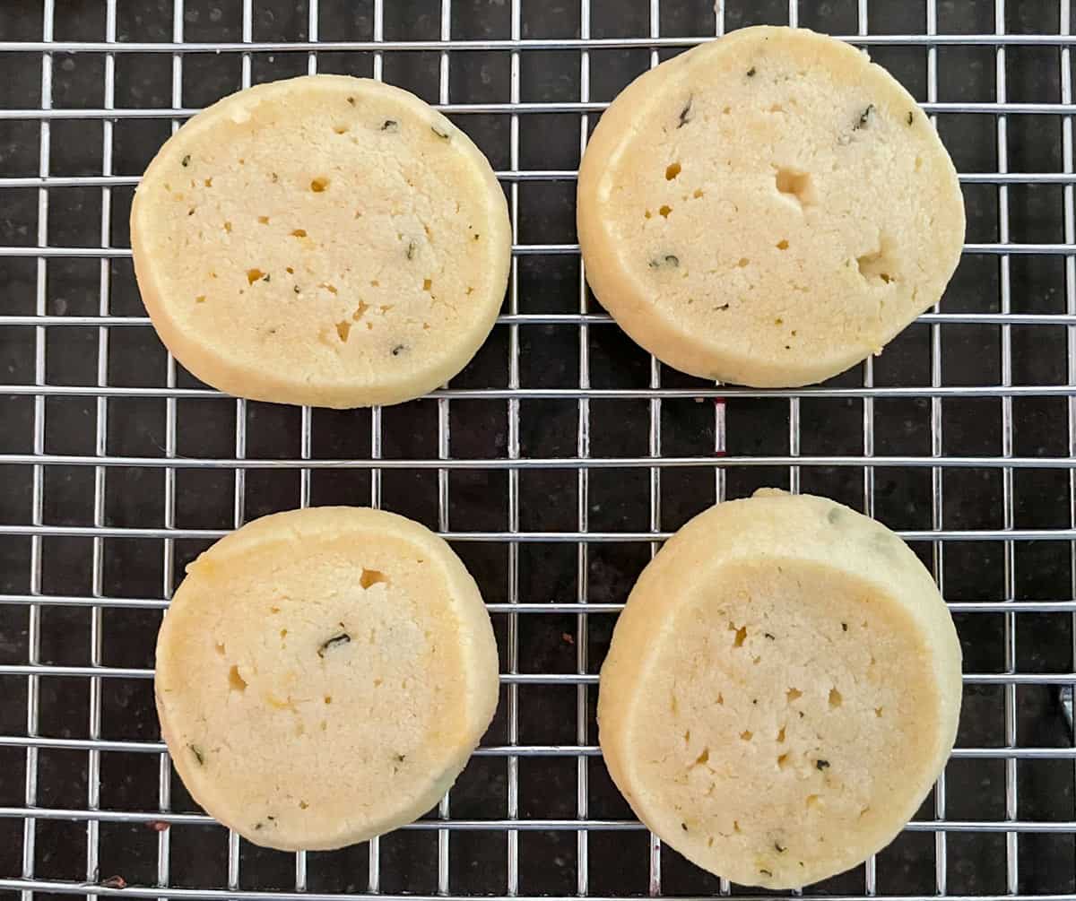 Four shortbread cookies cooling on rack.