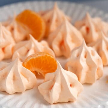 Orange meringue cookies on a white plate.