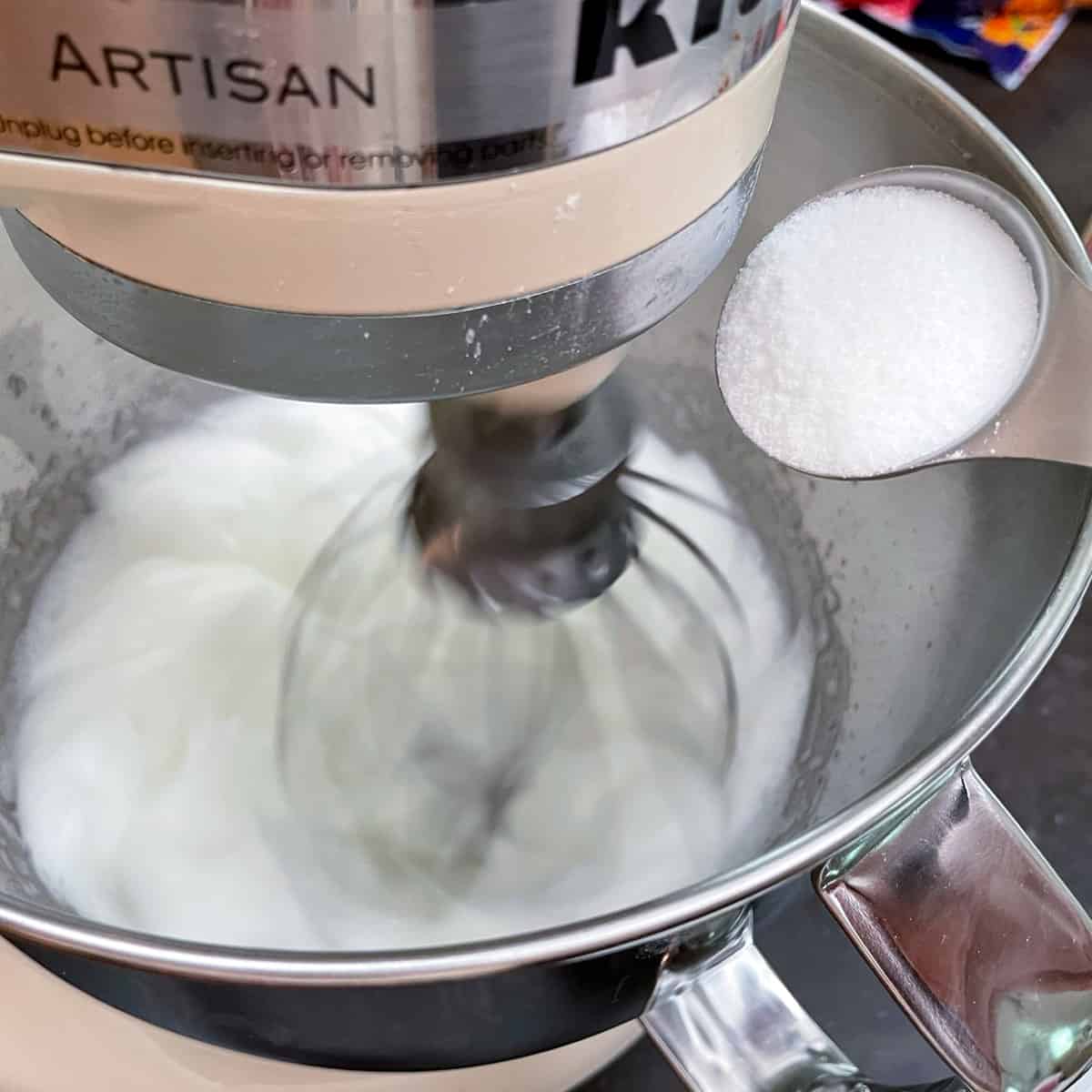 Whipping egg whites and adding 1 tablespoon of sugar at a time.