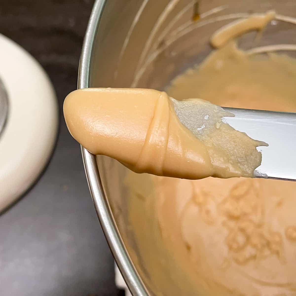 Clow up of brown sugar icing on the end of a knife.
