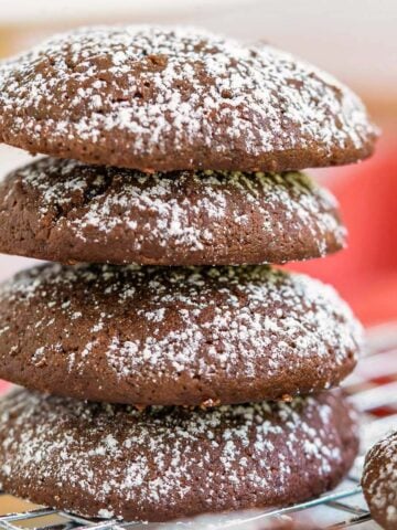 Stack of 4 chocolate cream cheese cookies with powdered sugar on top.