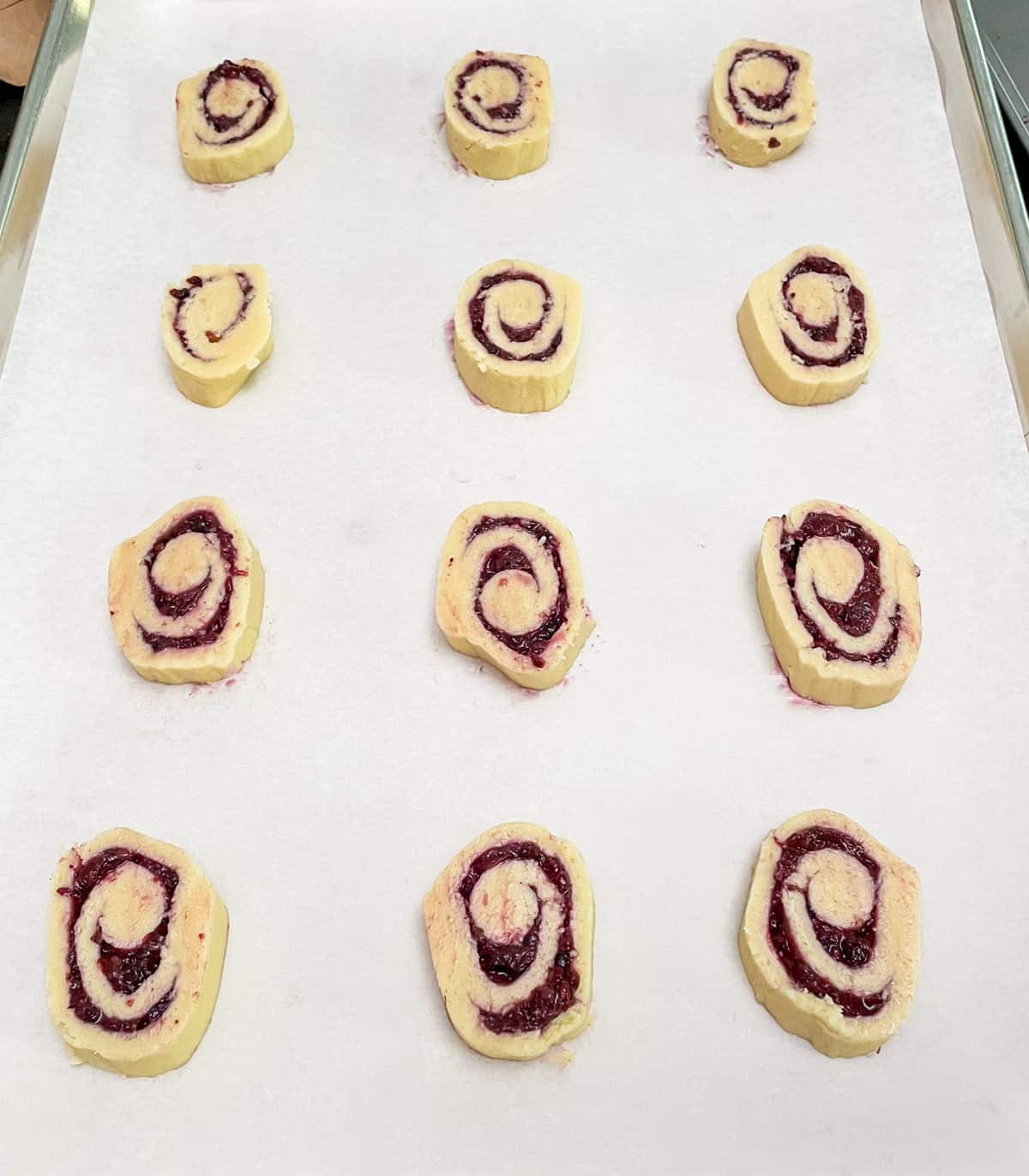 Blackberry roll sliced and added to a parchment lined baking sheet pan.