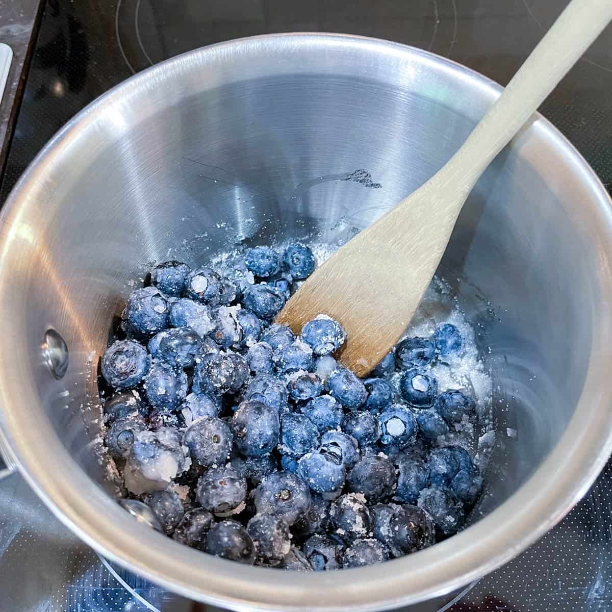 Sugar and blueberries in a saucepan.