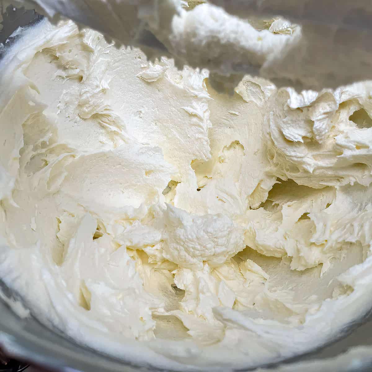 Fluffy butter, cream cheese and sugar in a mixer bowl.