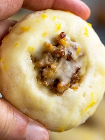 Walnut Date with Honey Orange Glaze Cookie being held to show the front view of cookie.