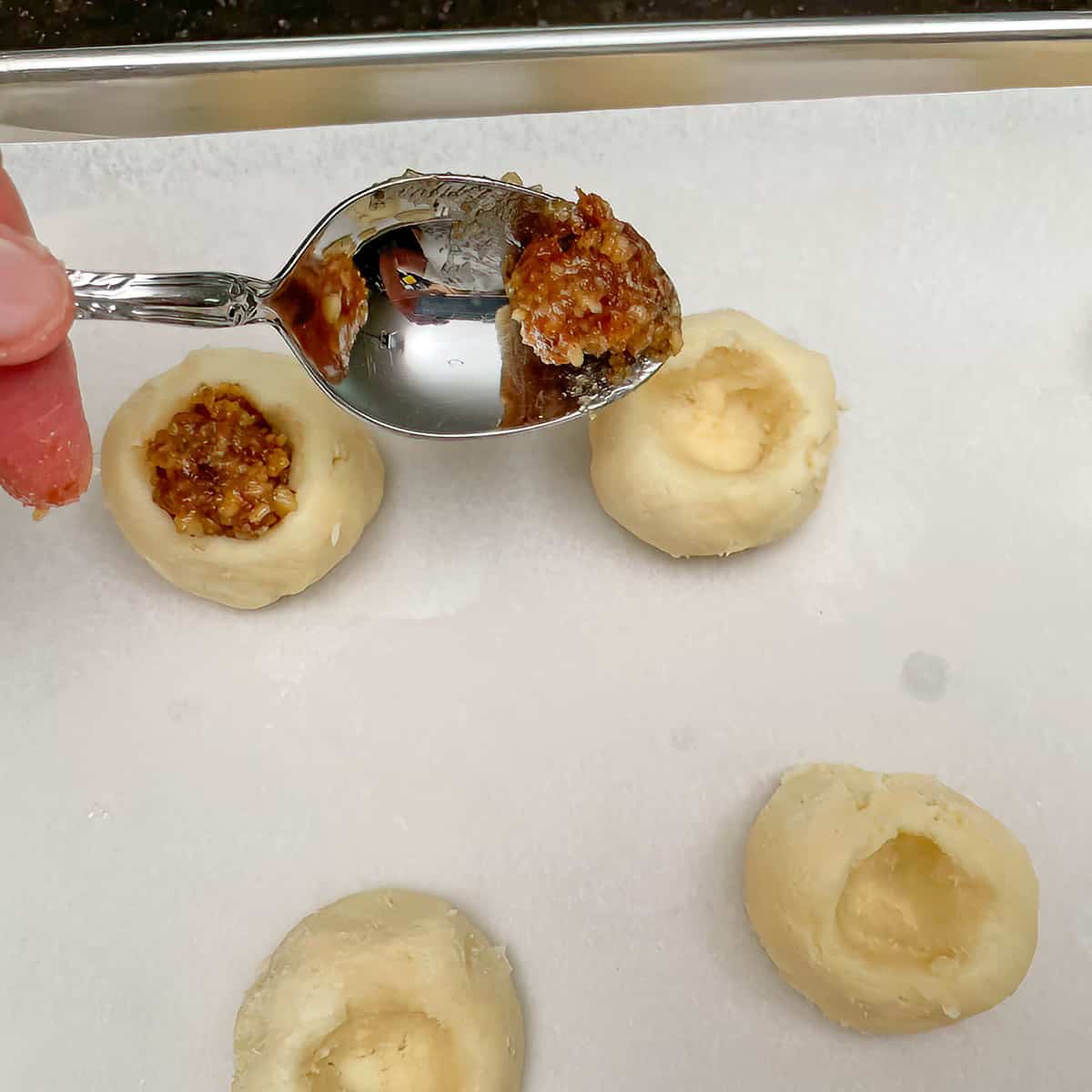 Spoon with the amount of filling to go into each cookie well.