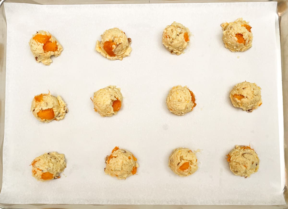 Twelve apricot cookies cookie mounds getting ready for the oven.