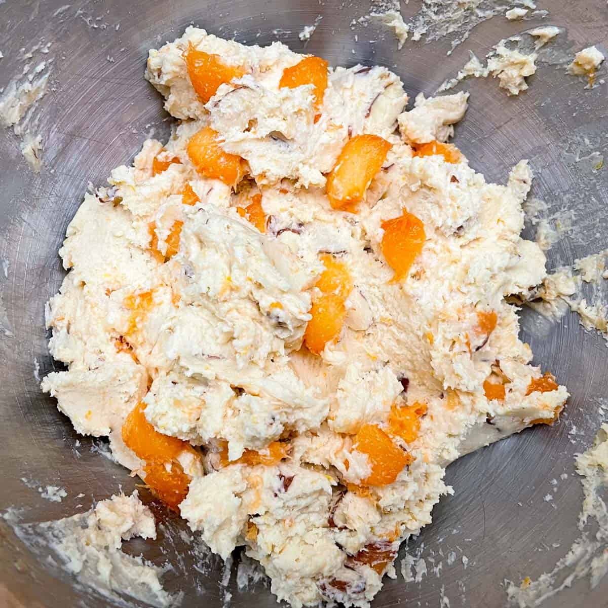 All ingredients in the mixing bowl with chunks of apricot throughout the cookie dough.