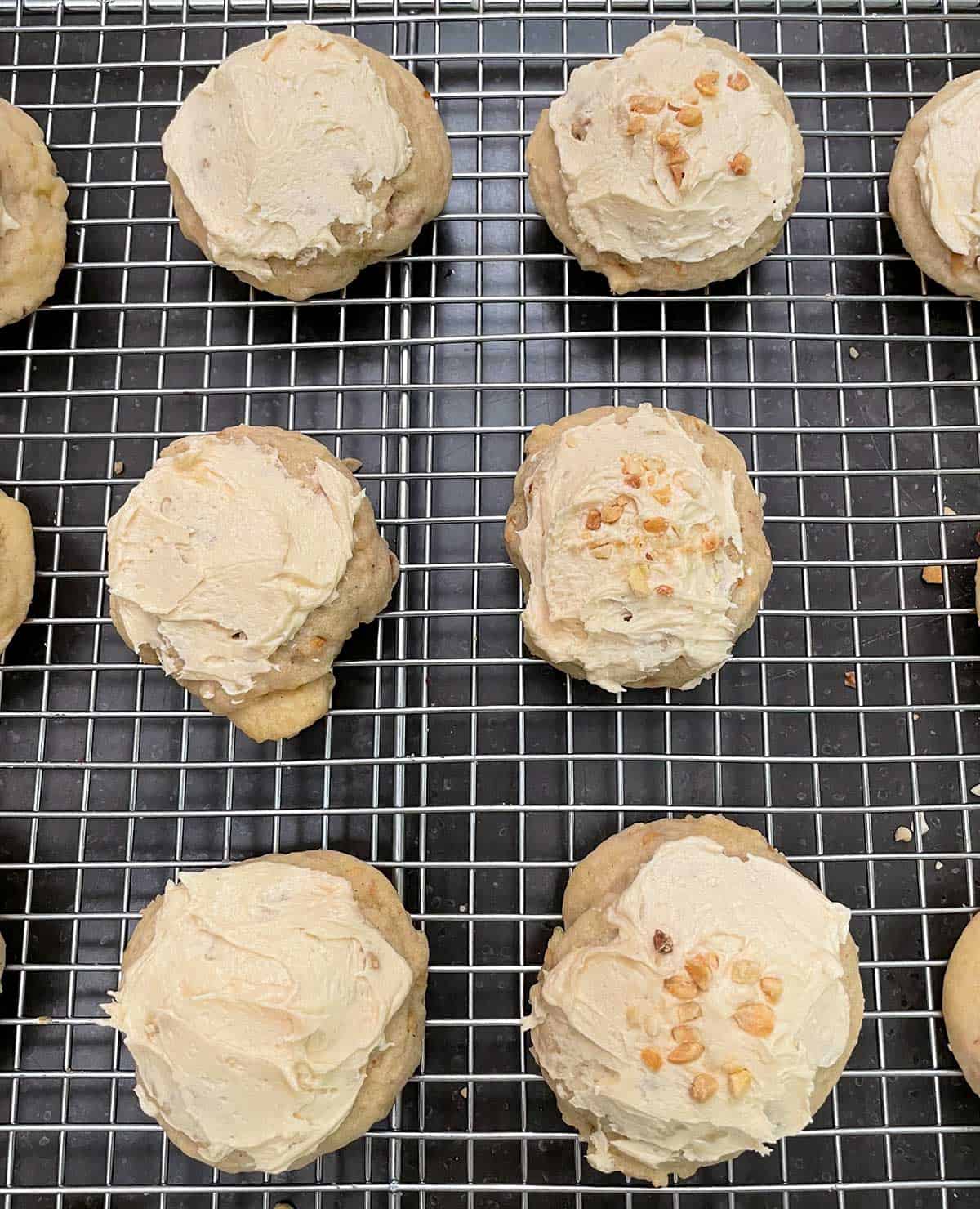Cookies half with just icing and half with icing and chopped peanuts on top.