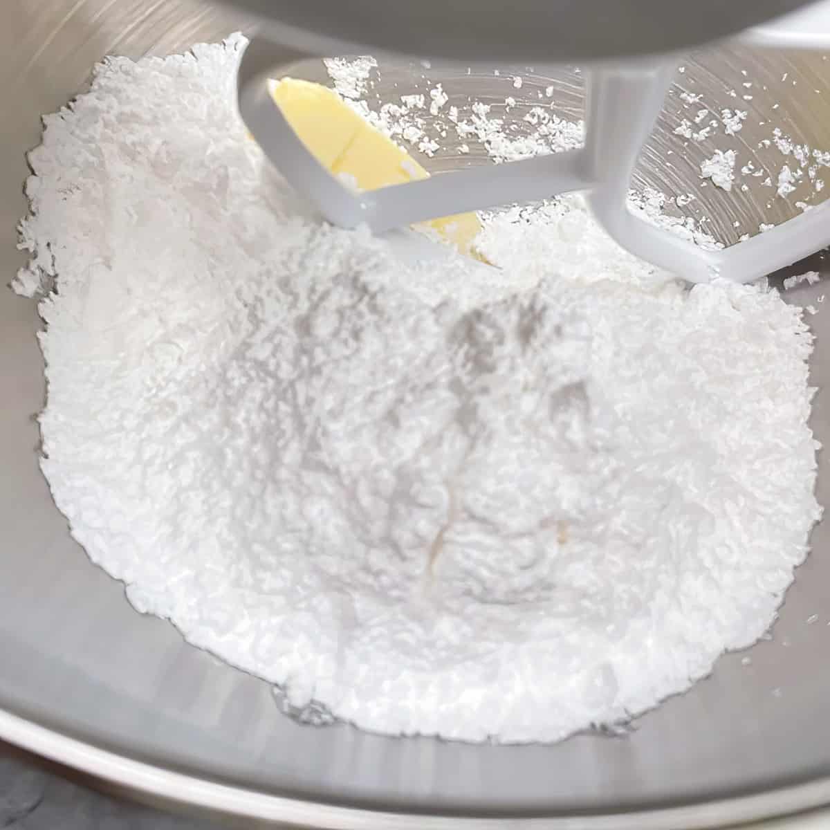 Powdered sugar in the mixer bowl for caramel buttercream icing.