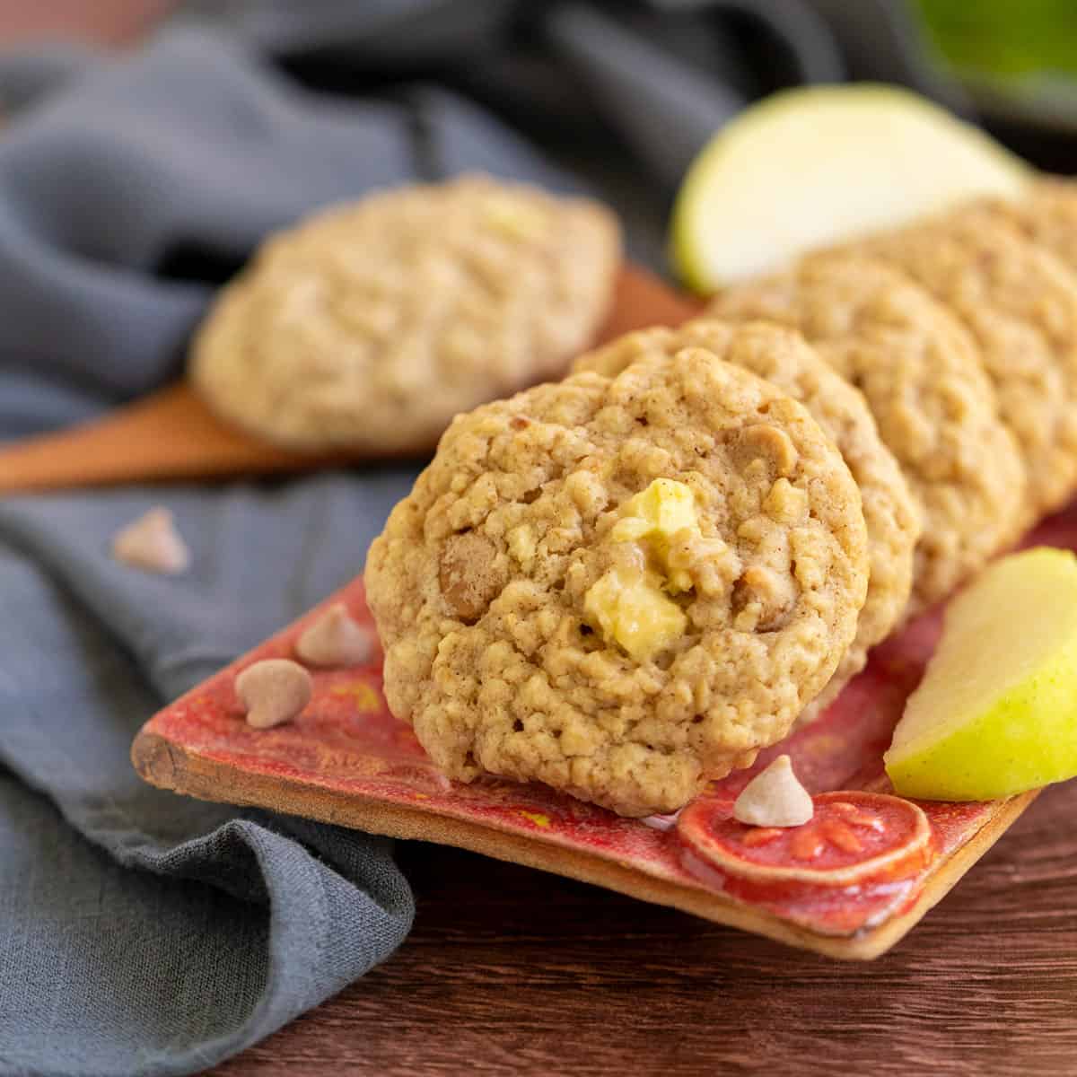 A line of oatmeal cookies on a red plate.