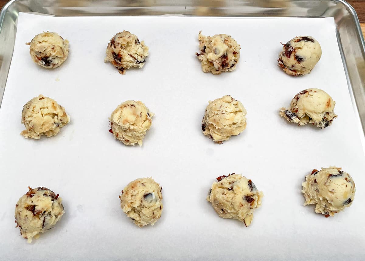 Twelve mounds of cookie dough before they are flattened.