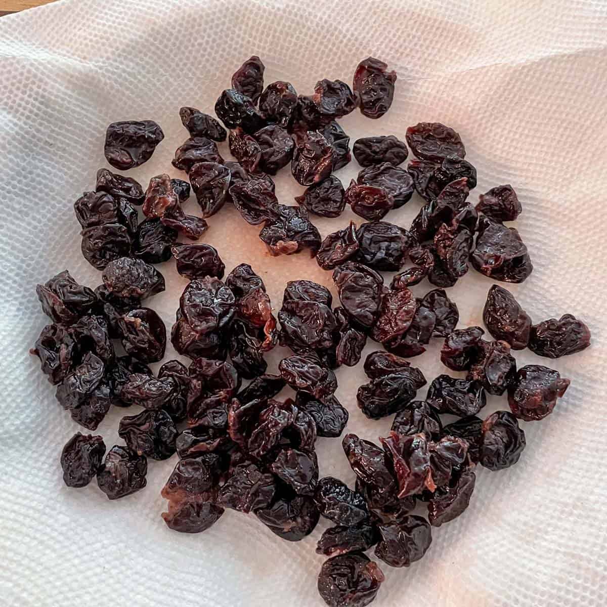 Infused dried cherries laying on a paper towel to absorb the liquid.