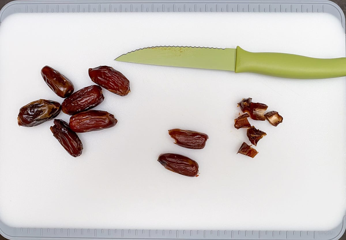 Cutting dates in half and then cutting them into small pieces.