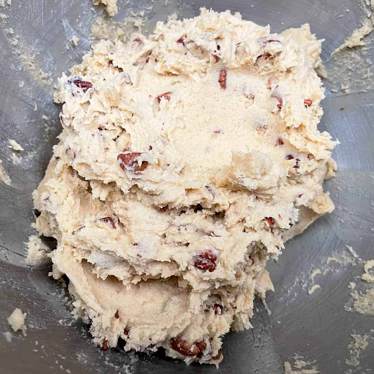 All ingredients mixed for the maple butter pecan cookies in a mixer bowl.