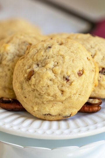Close up of a maple butter pecan cookie on a white plate.