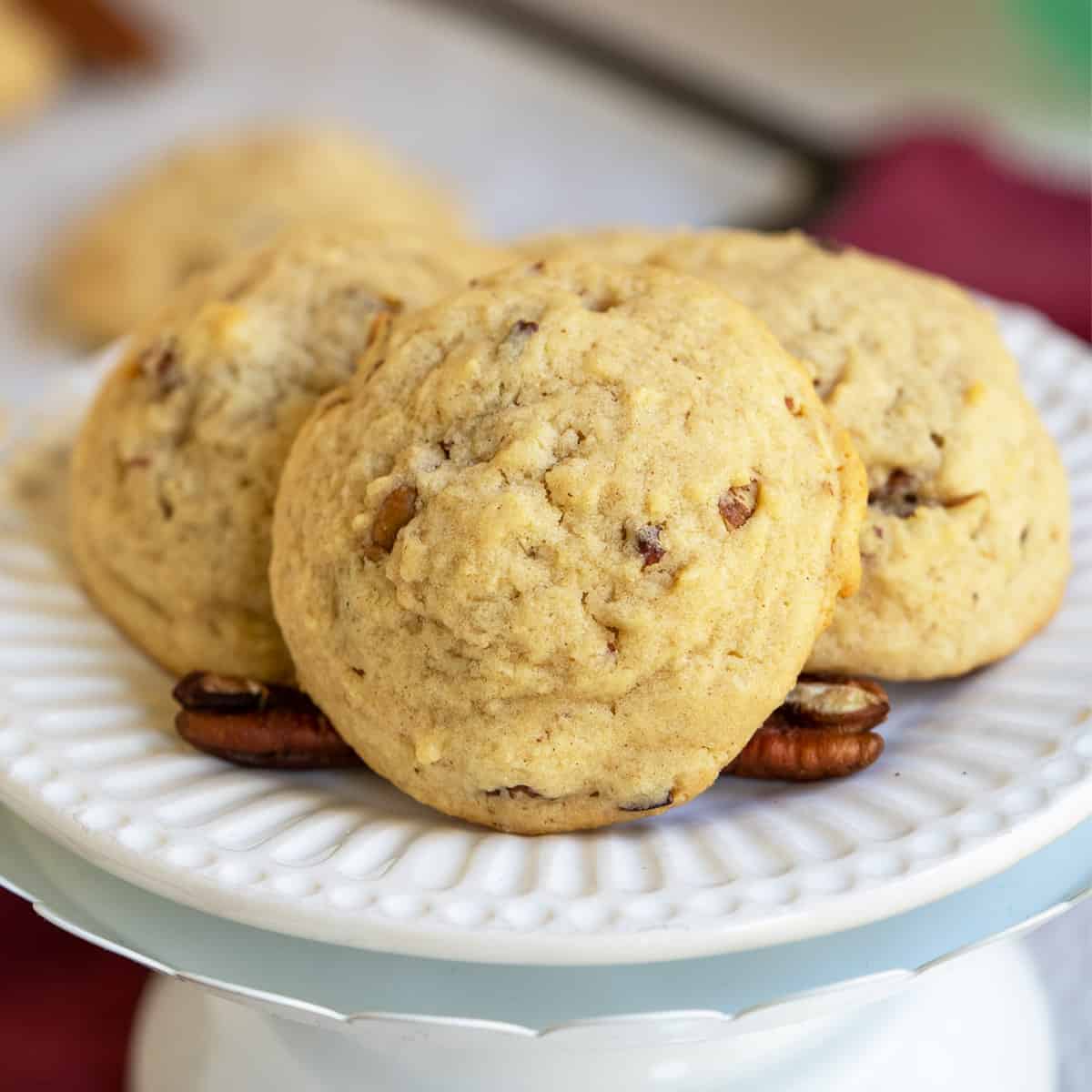 Close up of a maple butter pecan cookie on a white plate.