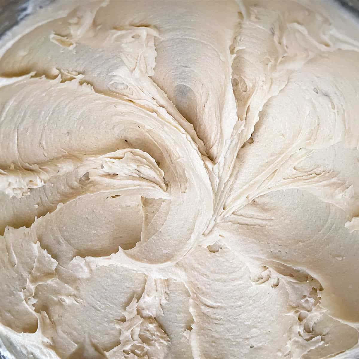Butter, cream cheese and sugars looking light brown and creamy swirls.