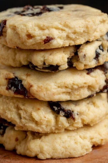 Single stack of sweet cherries with white chocolate cookies on a wooden surface.