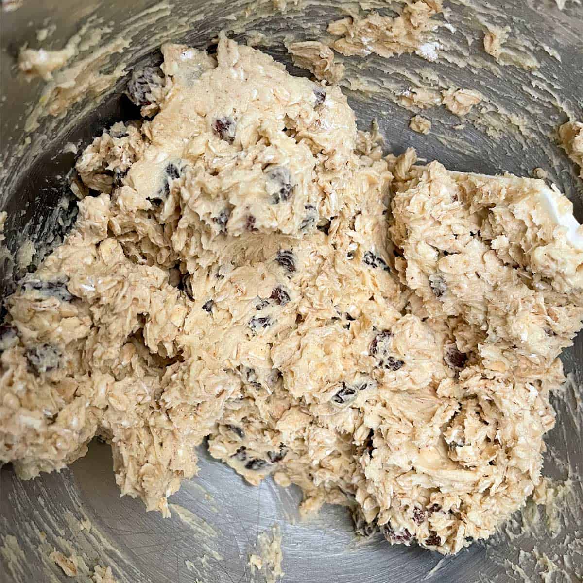 Oatmeal cookie cookie dough all mixed in a mixer bowl.