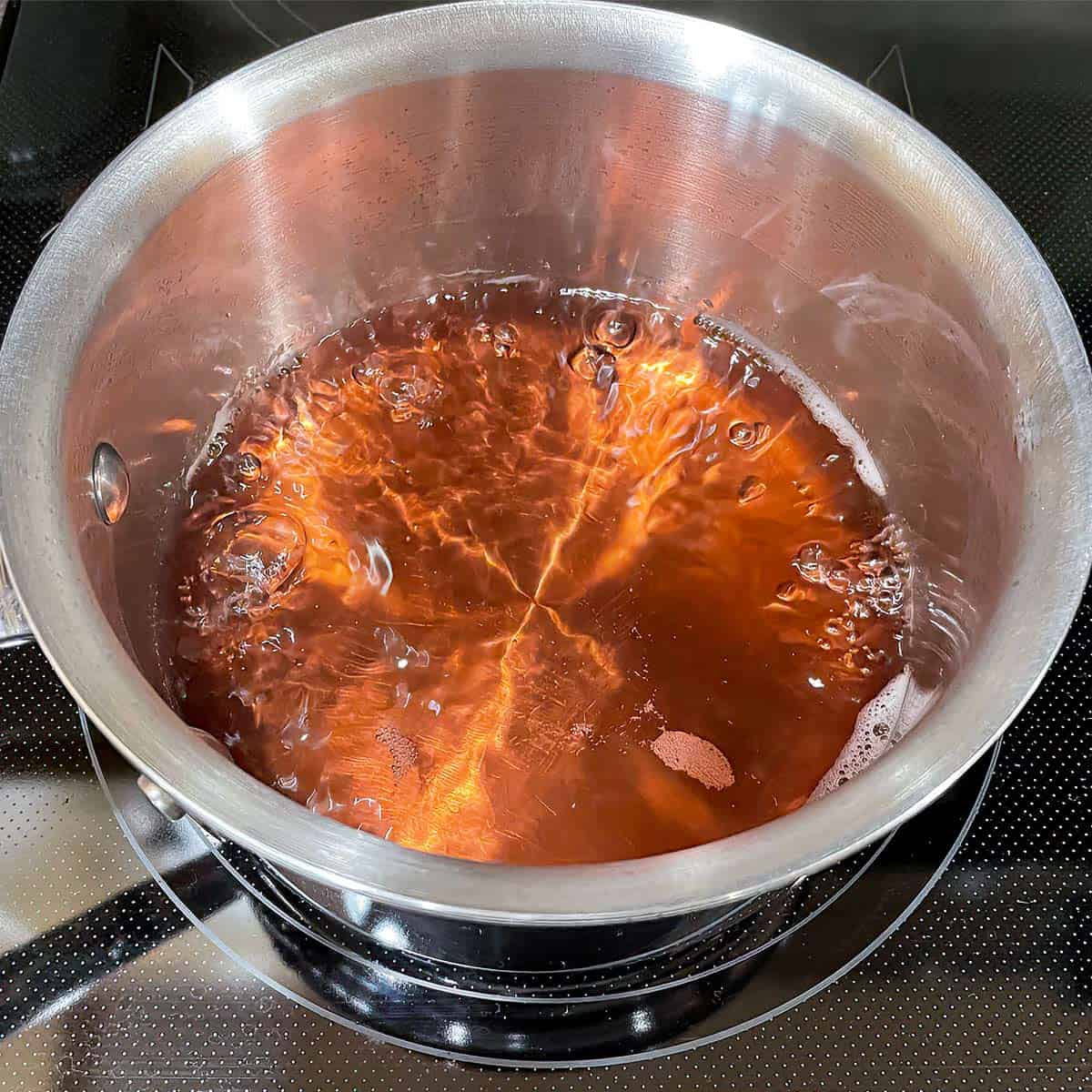 Rose champagne just starting to boil in a saucepan.