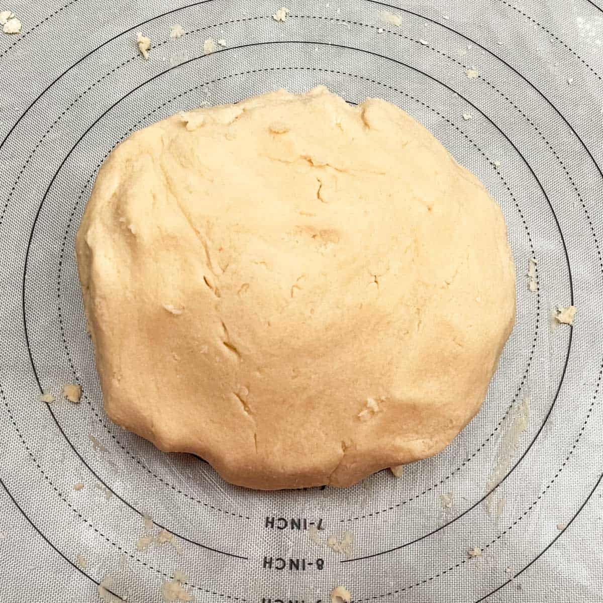 Cookie dough added to a pastry mat to finish bringing all the dough together.