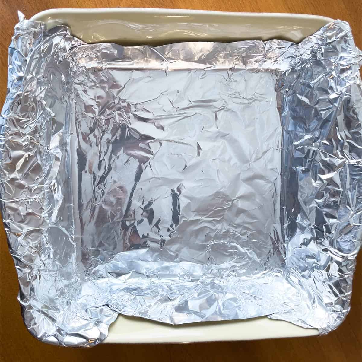 How to line a baking dish with tinfoil for cheesecake.