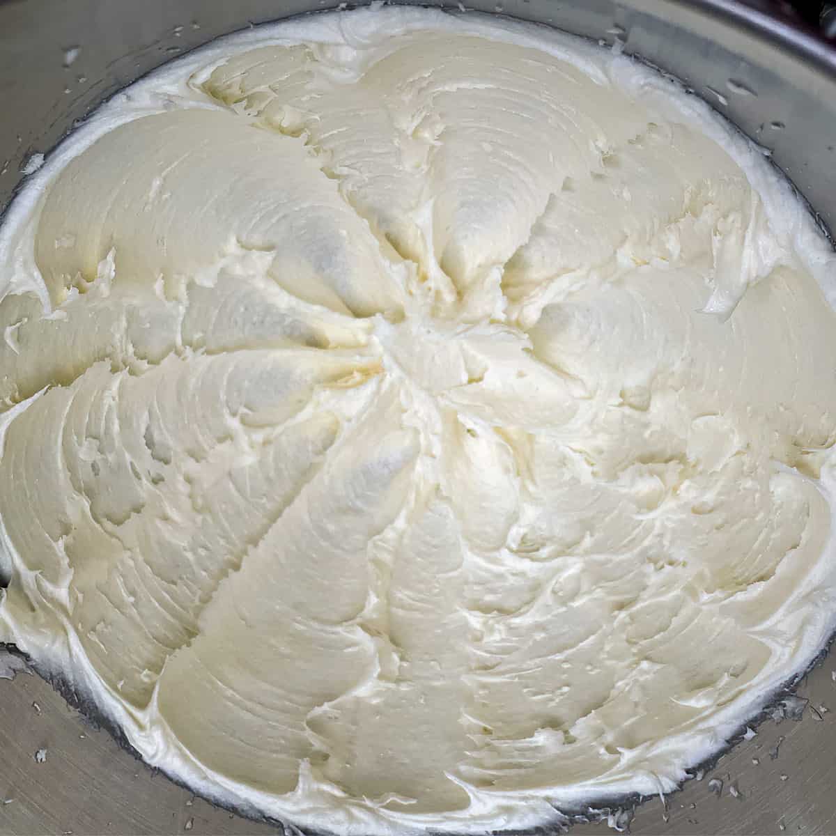 After being mixed for 3 minutes, how creamy the butter, cream cheese and the sugar look in the mixer bowl.