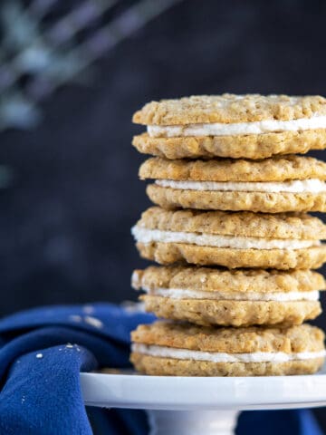 Oatmeal cream filled cookies in a stack of five on a white plate.