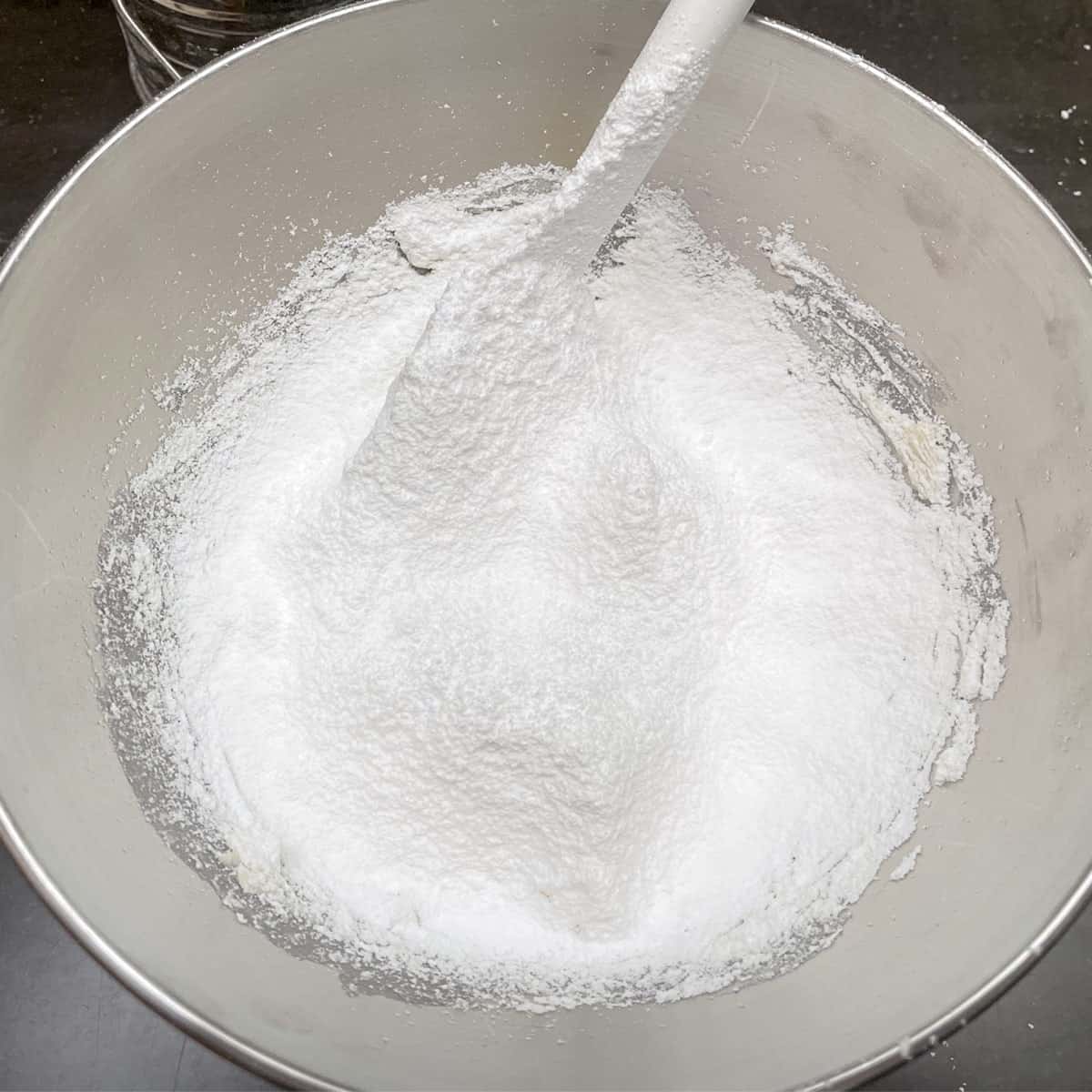 Sifted powdered sugar in a mixer bowl for the middle cream of the cookie sandwich.