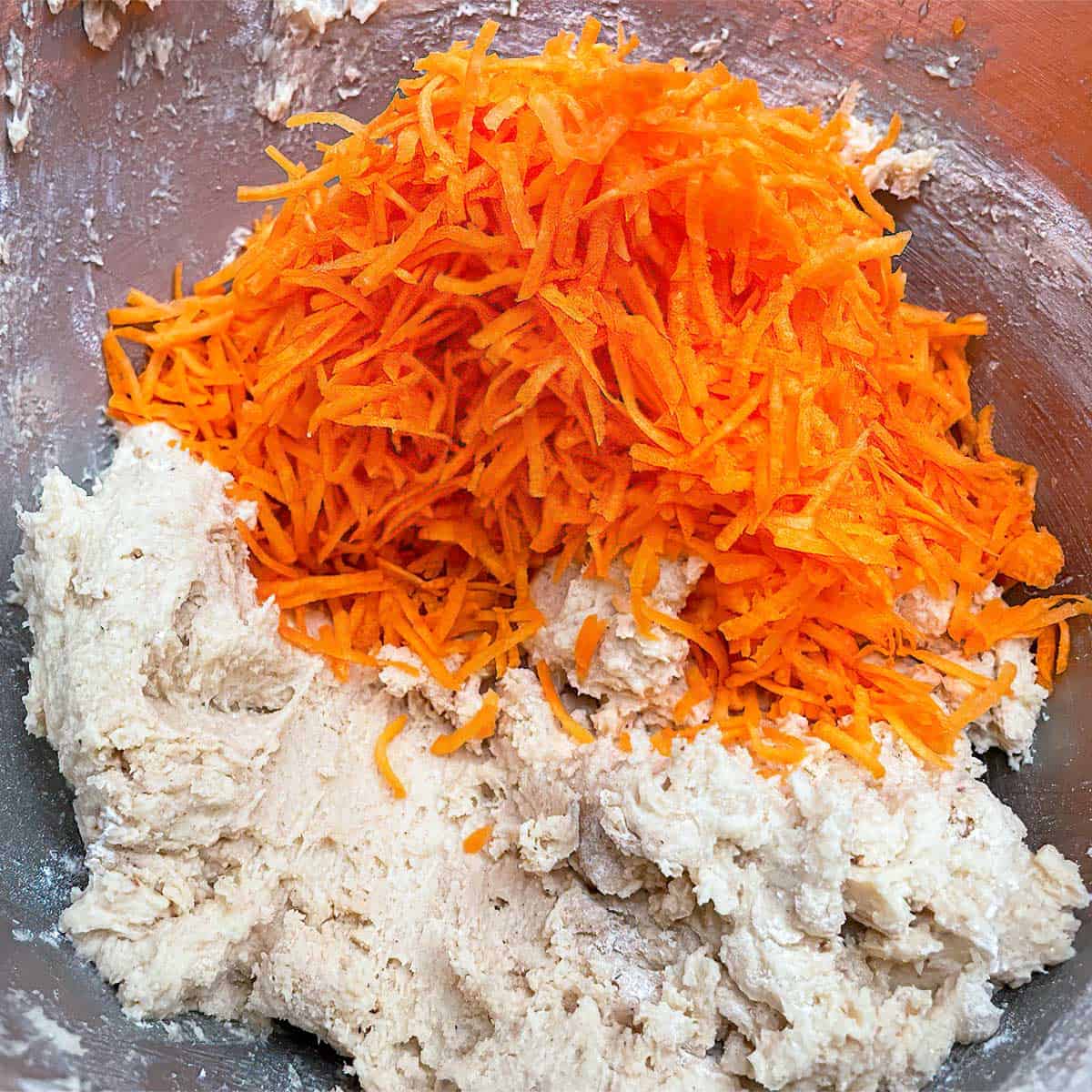 Cookie dough with shredded carrots ready to be mixed in.