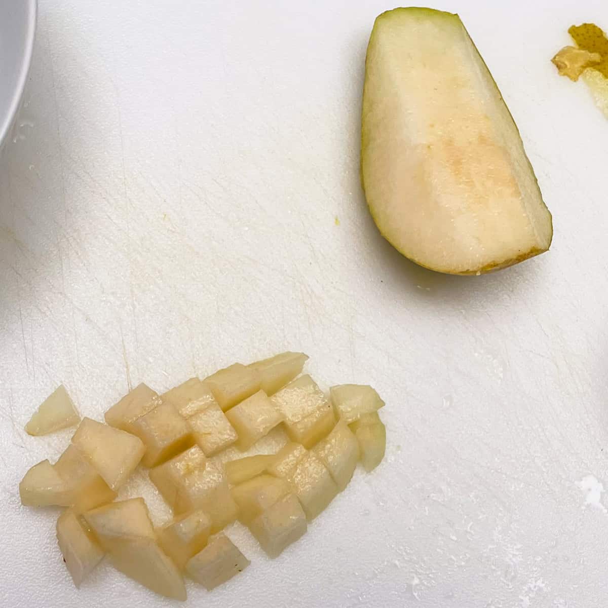 Pealed and cut up pear on a cutting board.