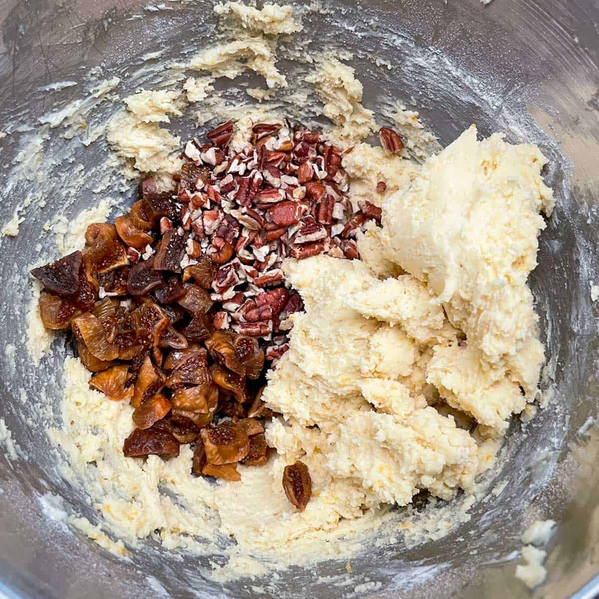Figs and pecans added to the cookie dough in a mixer bowl.