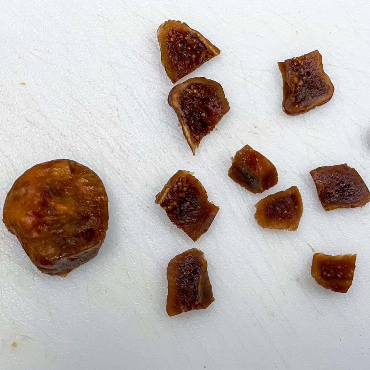 Cutting up a fig into cookie size pieces.
