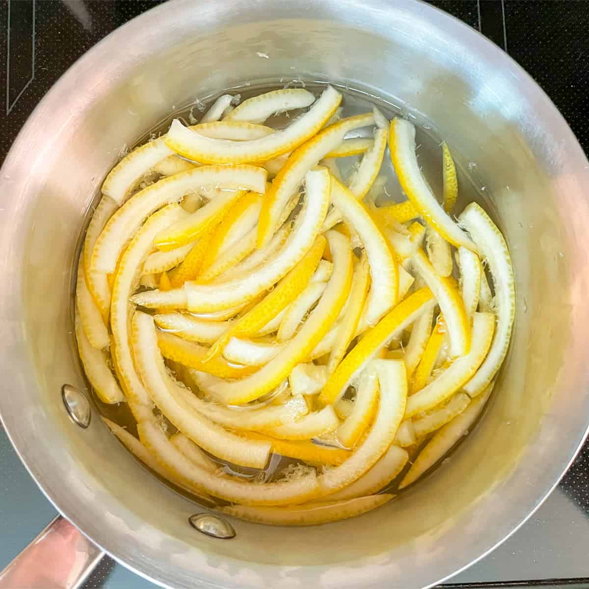Blanching lemon peel in a saucepan.