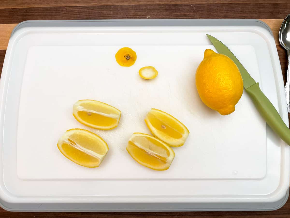 Cutting a lemon into quarters.